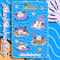 StarSticker.Shop KB Beach Relaxation sticker sheet featuring cute white magical cat KB relaxing on pool floats, lounging under an umbrella, napping on the beach, and building sandcastles.